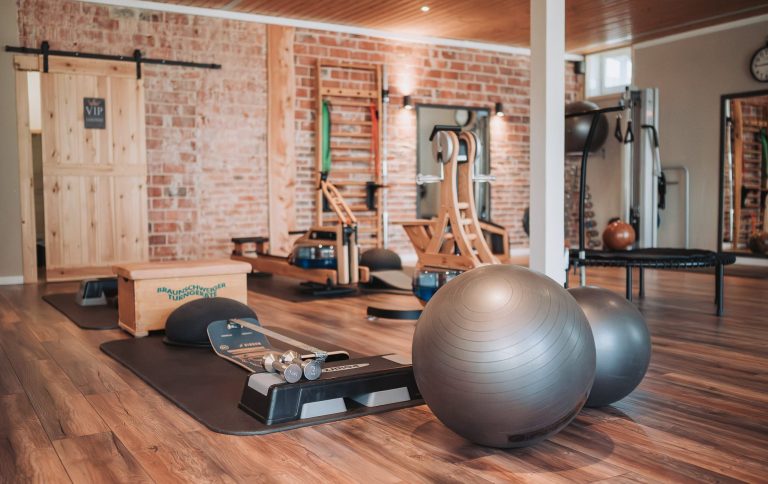 Die Physio Schmiede-Trainingsraum Balance Parcours Geräteraum in der Physiotherapiepraxis mit Sprossenwand, Wasserrudergerät, Gymnastikbällen und einem Balance-Parcours für Krankengymnastik.